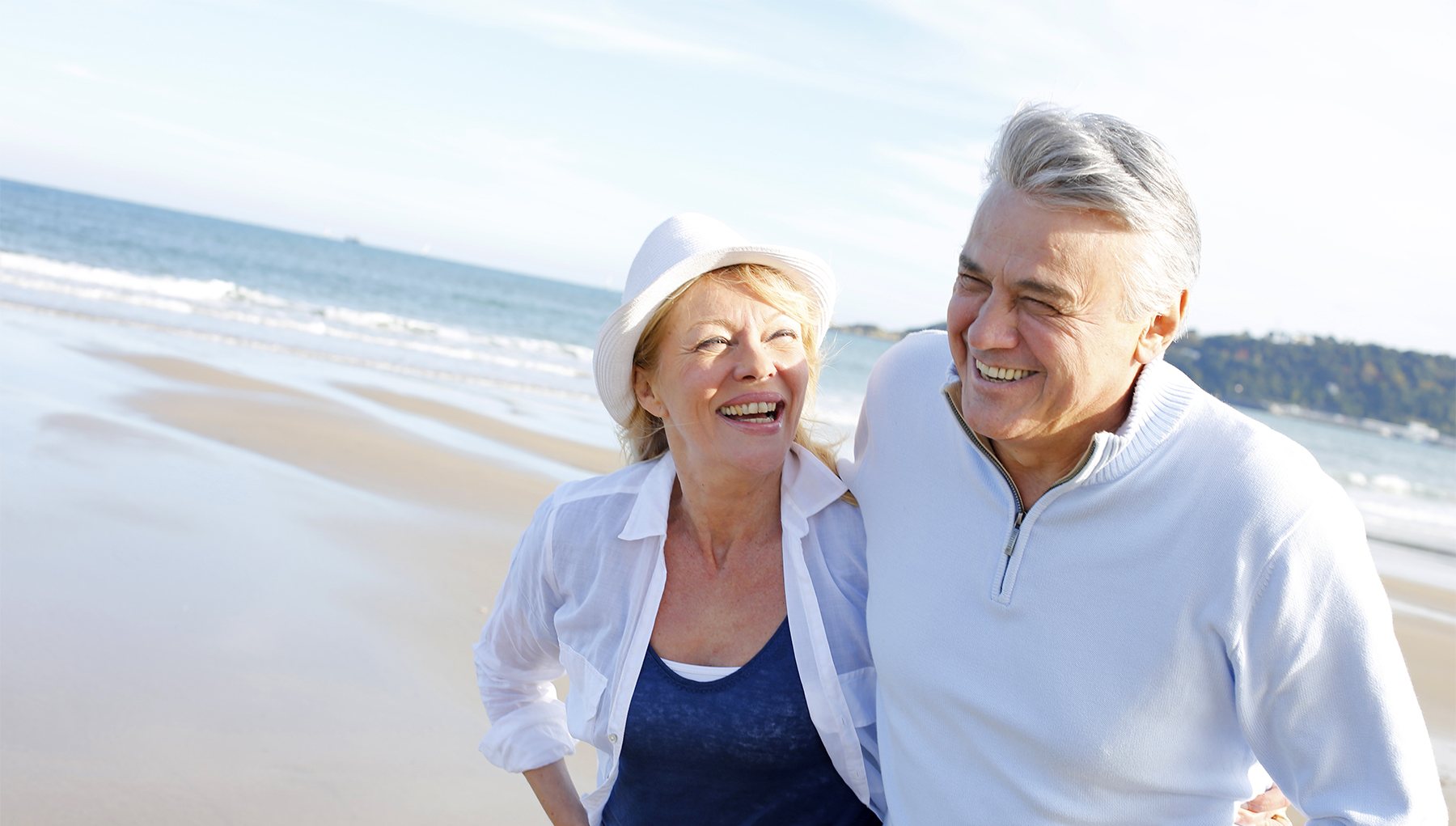 Senior couple walking on the beach in fall season